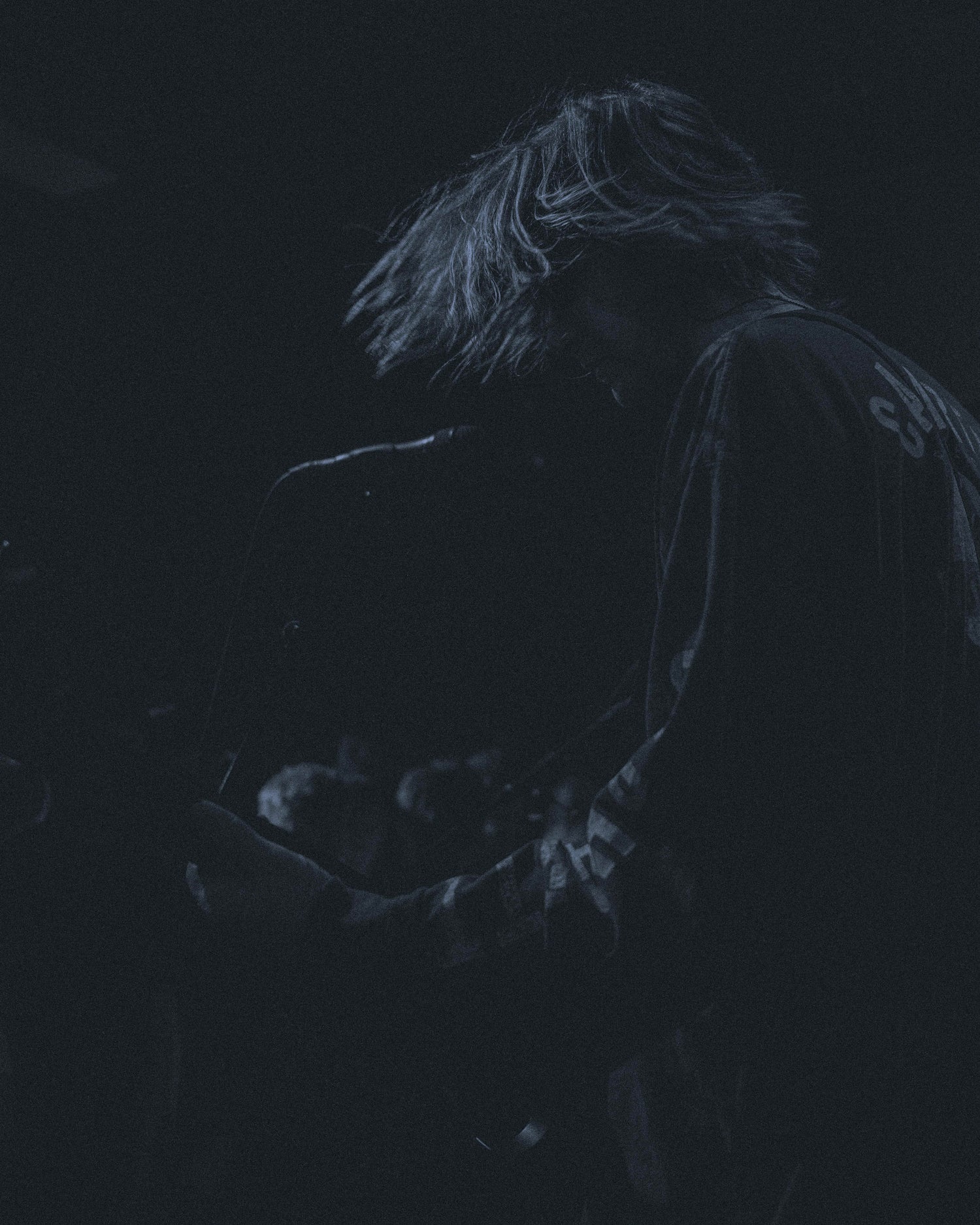Dark silhouette of Louis Christle from Basht playing guitar at the The Cluny in Newcastle